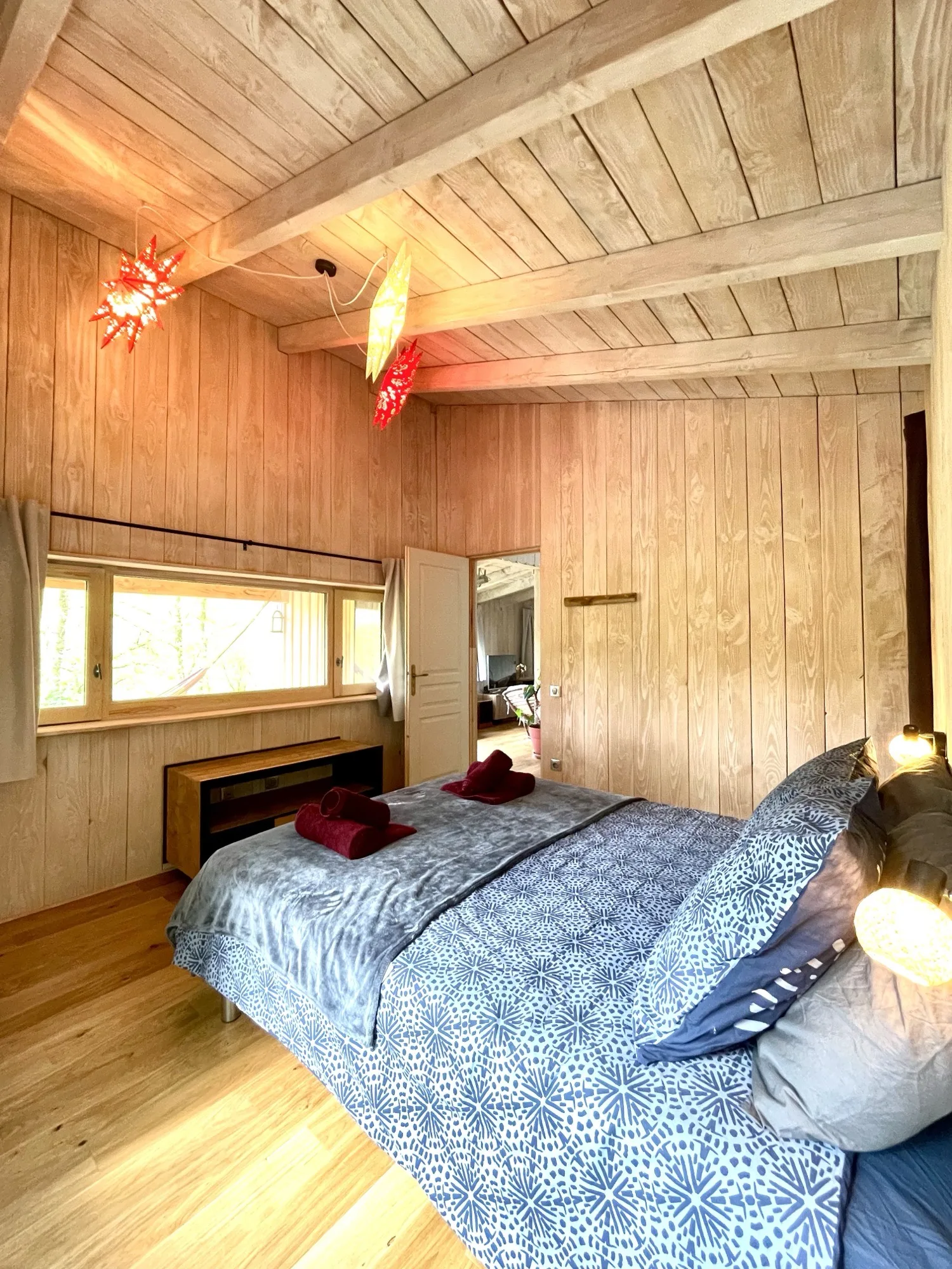 Chambre en bois avec lit double et lumières tamisées à Lalalandes
