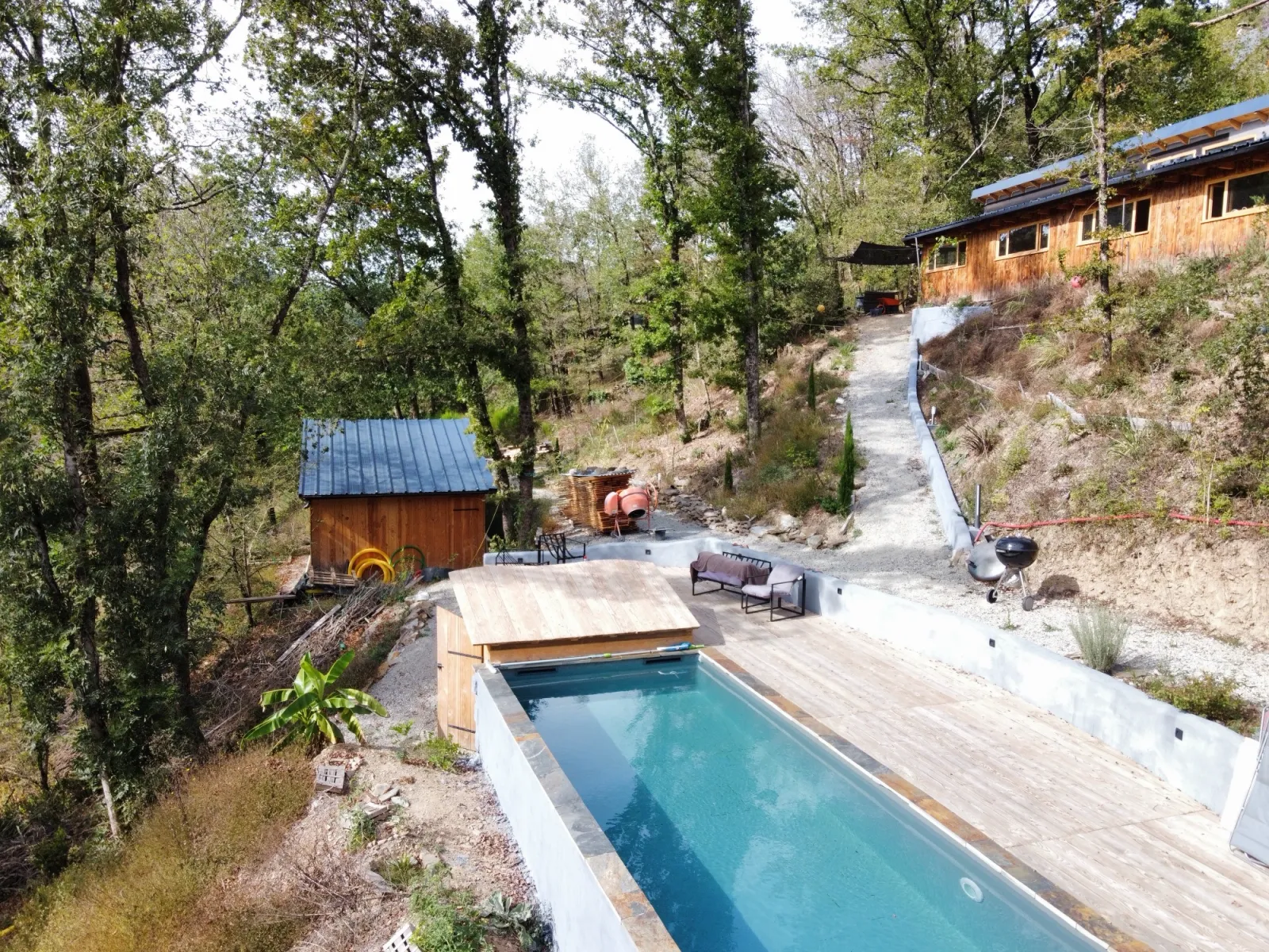 Aerial view of Lalalandes, a wooden house surrounded by forest in Aveyron