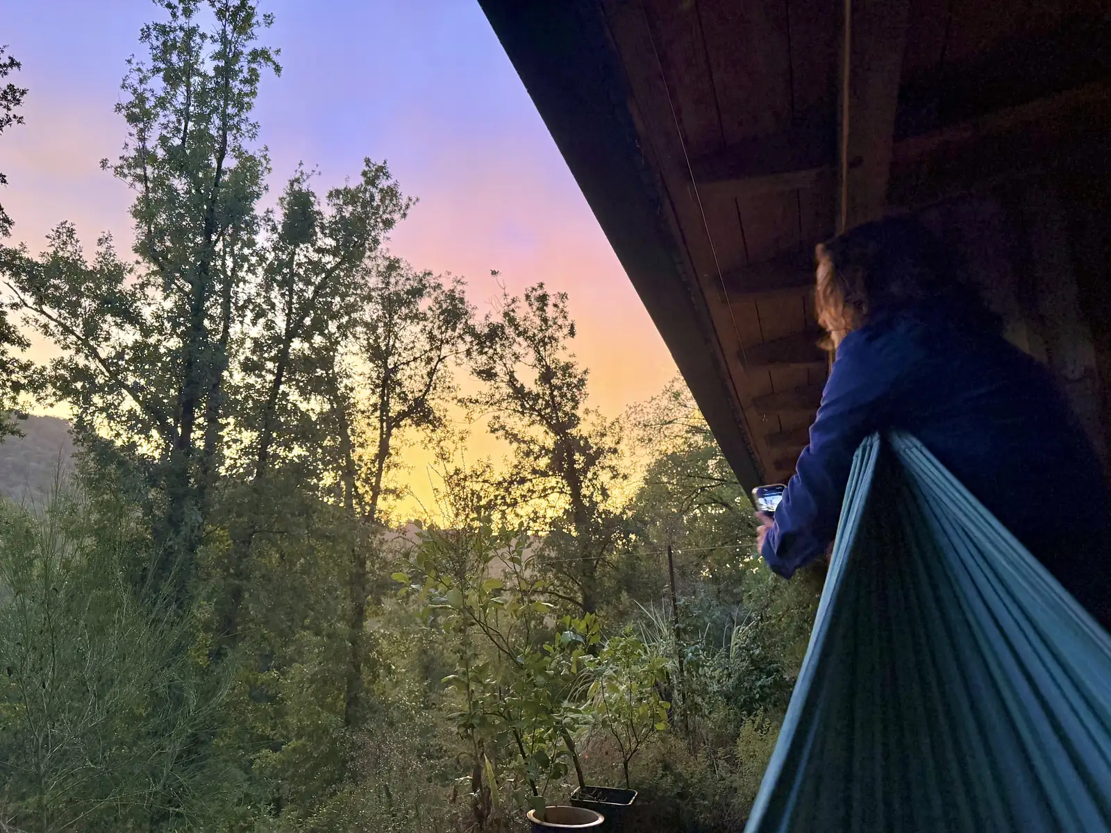 Hammock under the deck facing the sunset over the valley