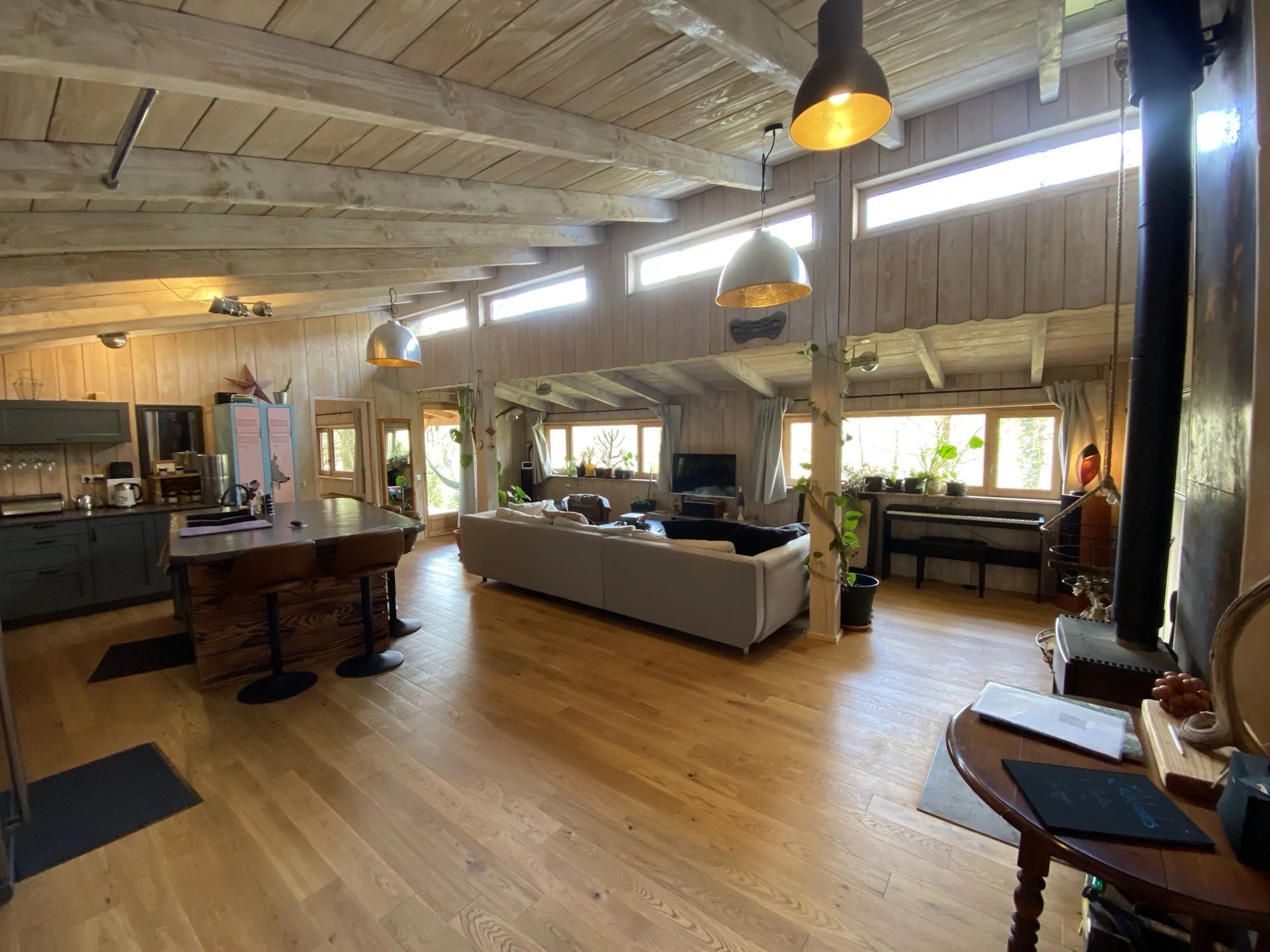 Grand salon de Lalalandes avec poutres apparentes et lumière naturelle