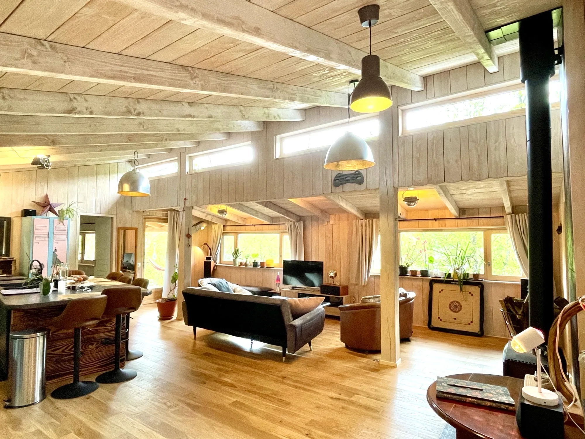 Salon de Lalalandes - grand espace de vie en bois avec poutres apparentes et lumière naturelle