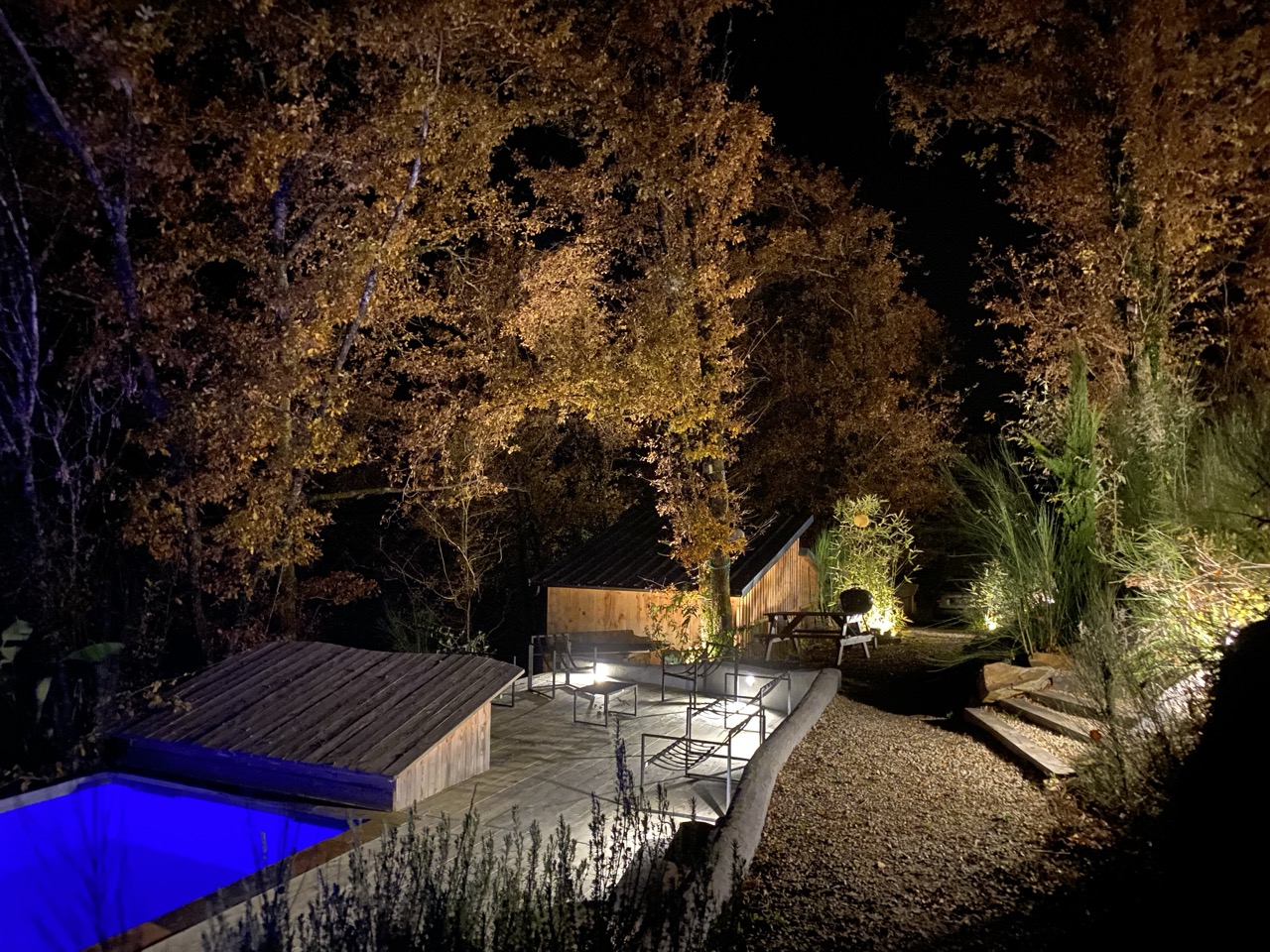 Vue nocturne du couloir de nage de Lalalandes illuminé en bleu, entouré de forêt